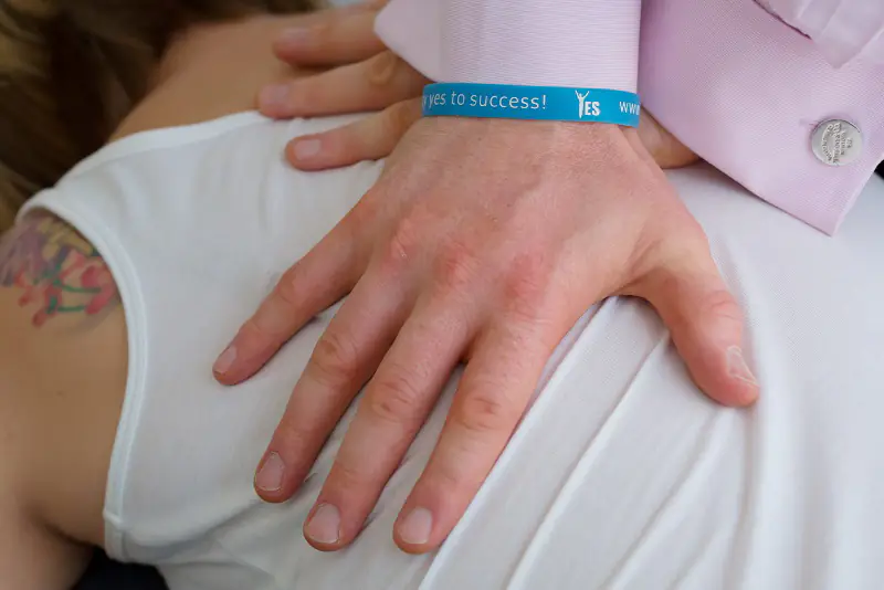 Close-up of a chiropractor's hands assessing a patient's mid-back